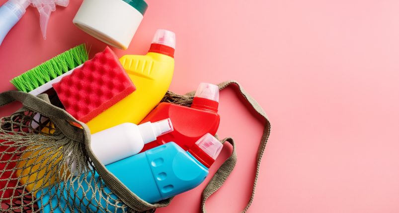 Cleaning products and housekeeping. Sanitary bottles and cleaning tools in eco-friendly mesh bag on